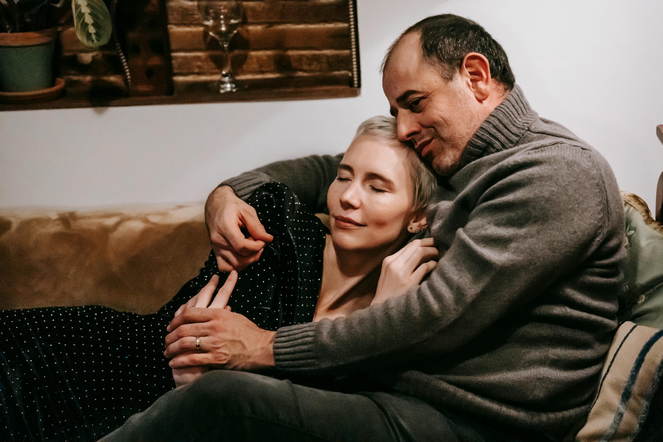 A couple in their 40s on the sofa together, close and at ease — representing restored intimacy and connection