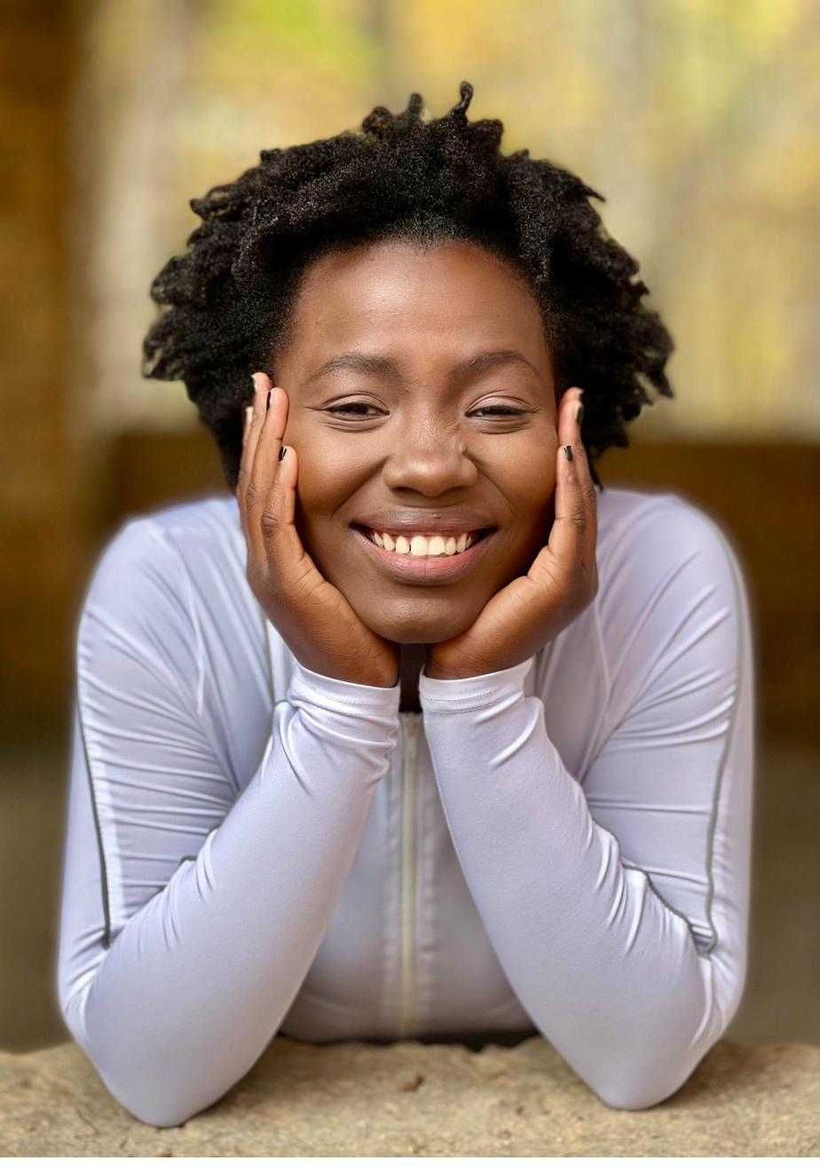 Woman smiling and holding a supplement capsule